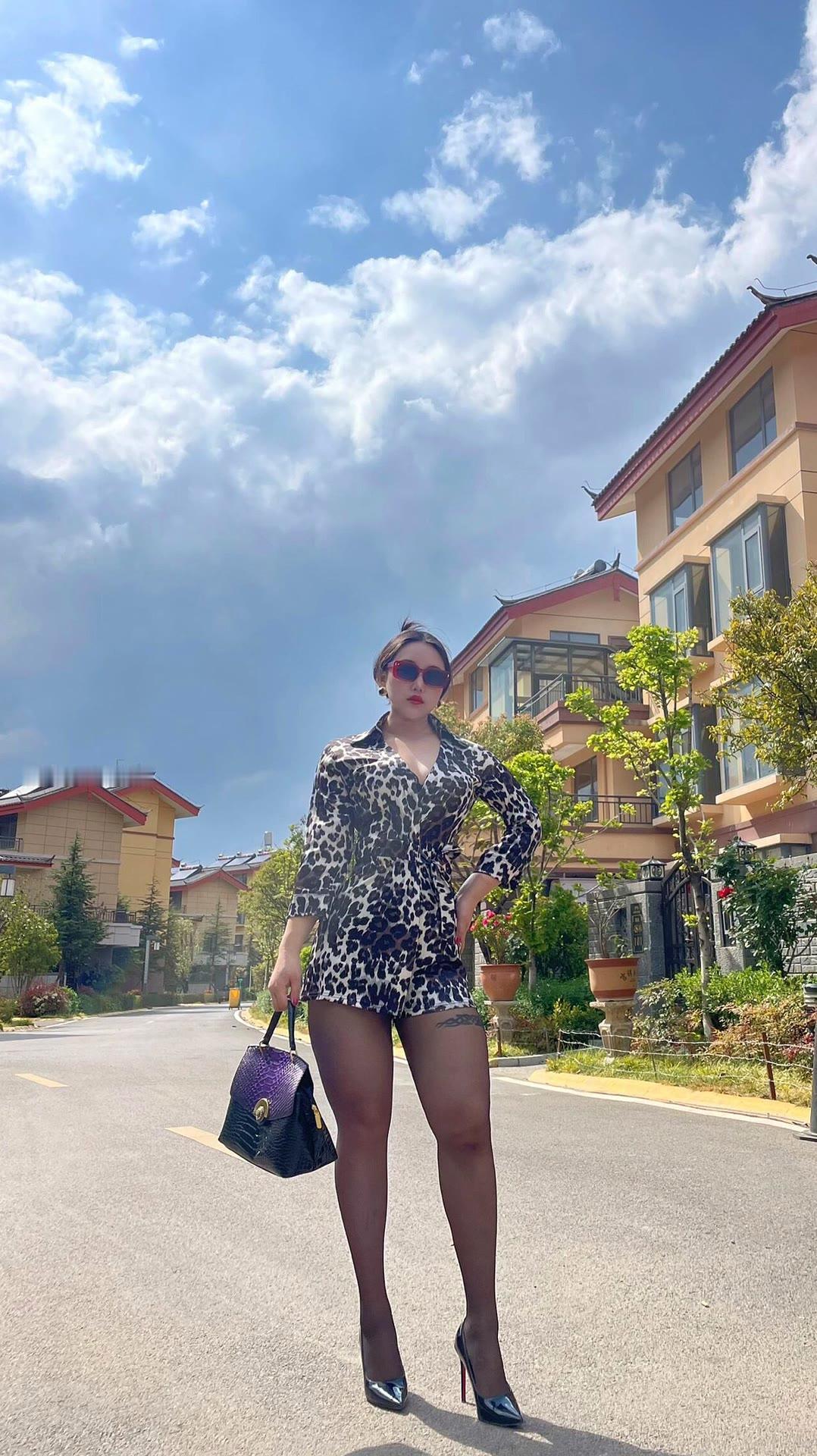 都市时尚女郎，豹纹连衣裙，手提包，高跟鞋，阳光明媚的街道。