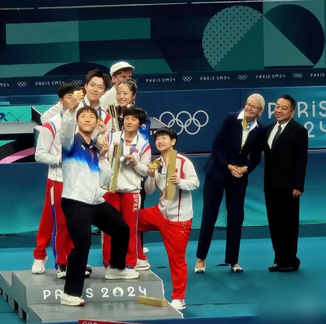 巴黎奥运会乒乓球混双颁奖的瞬间，一张大合照定格了永恒的温馨。六个来自异国小朋友，