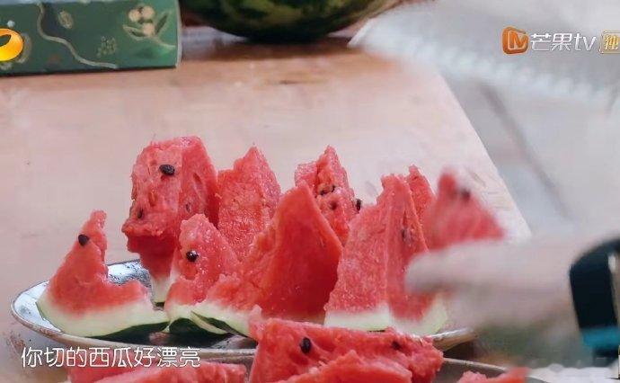 黄晓明徒手劈开两个西瓜，昆凌接着切块分给大伙吃。 