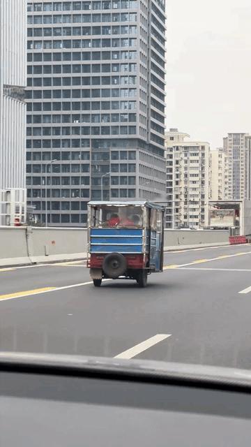 成都二环高架上的这辆三轮车还是知道点儿交通规则的嘛，晓得最左边的公交车专用道，所