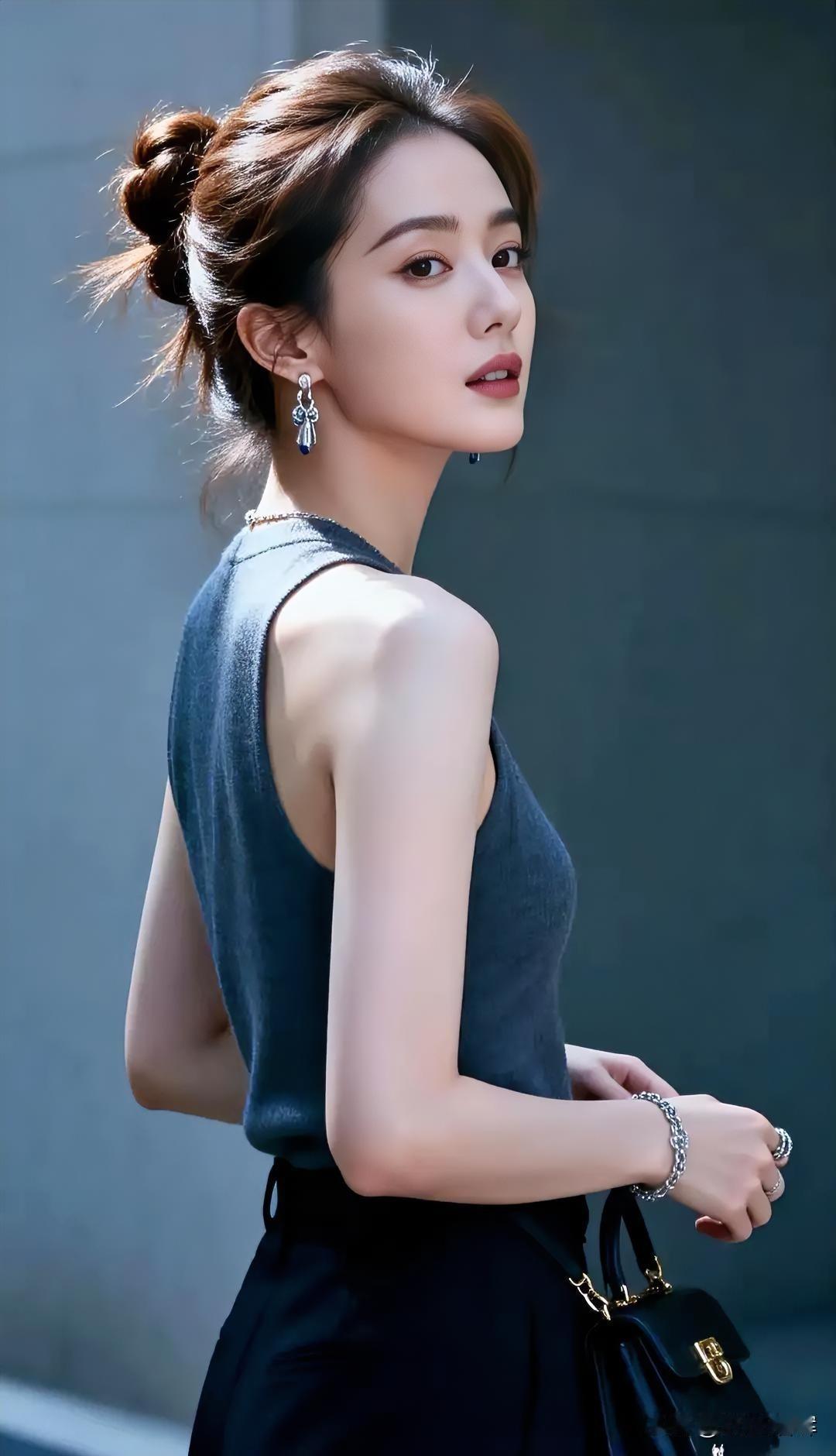 灰蓝针织拥着肩线，她立成都市的诗。

无袖设计展着清瘦，背线流畅如溪流。

发髻