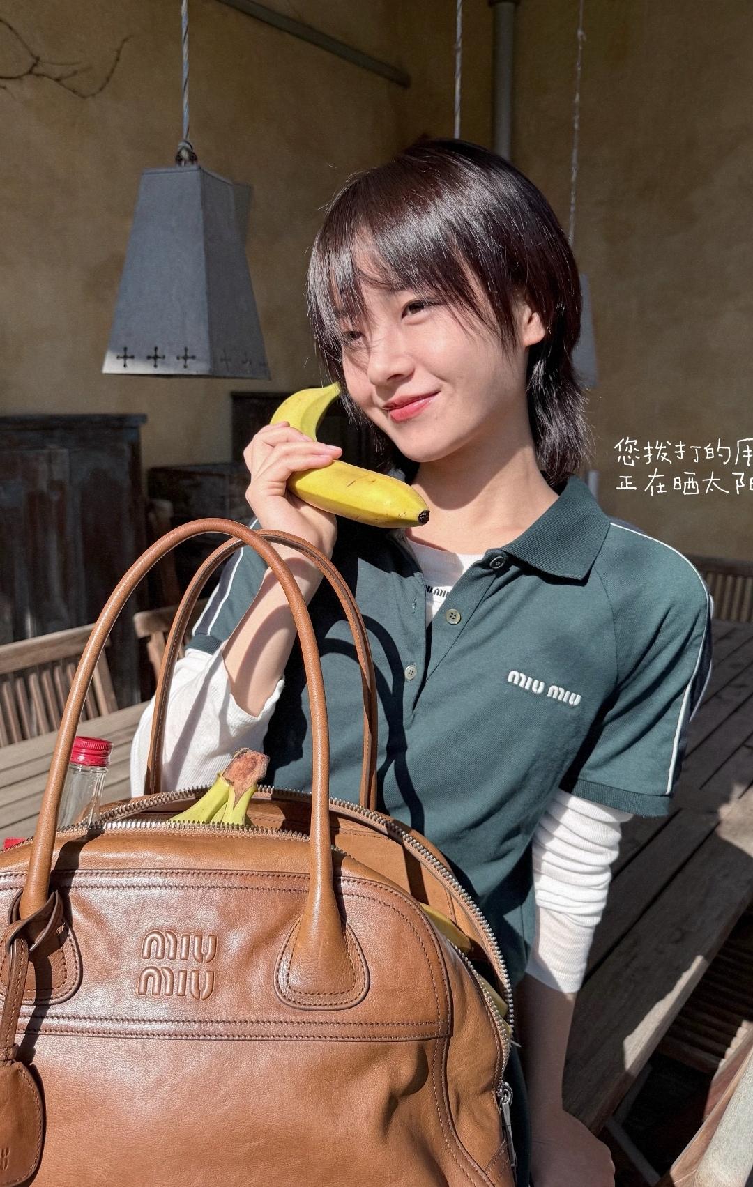 李庚希俏皮晒图发文：春天里的信号📶满满，照片中她右手拿着一根黄色的香蕉，俏皮地