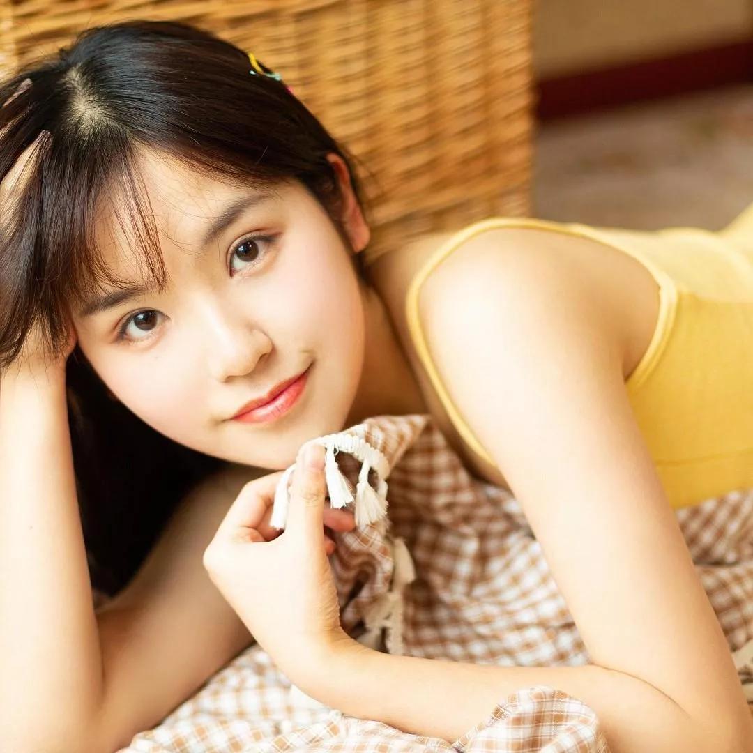 夏日午后，少女慵懒躺卧，手持冰淇淋，笑容甜美，阳光洒满脸颊。