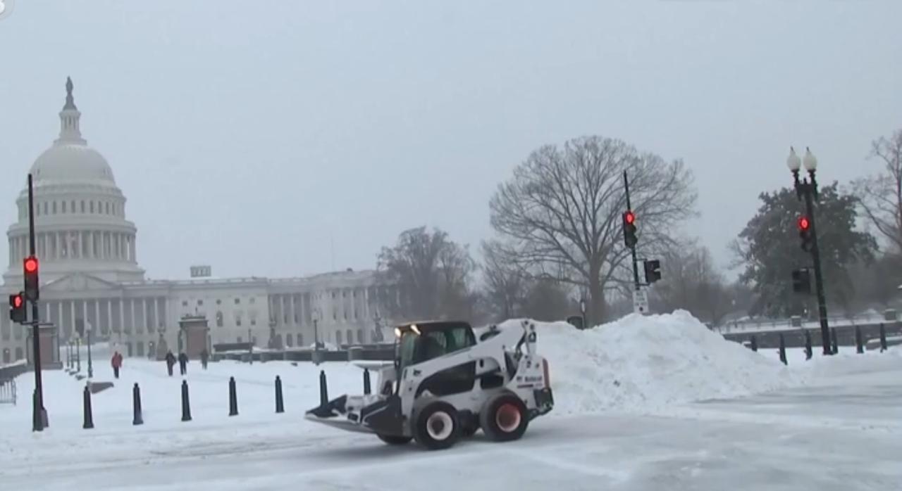 暴雪笼罩下的华盛顿，国会山与白宫在风雪中显得格外冷清，铲雪车正紧急清理道路，而一