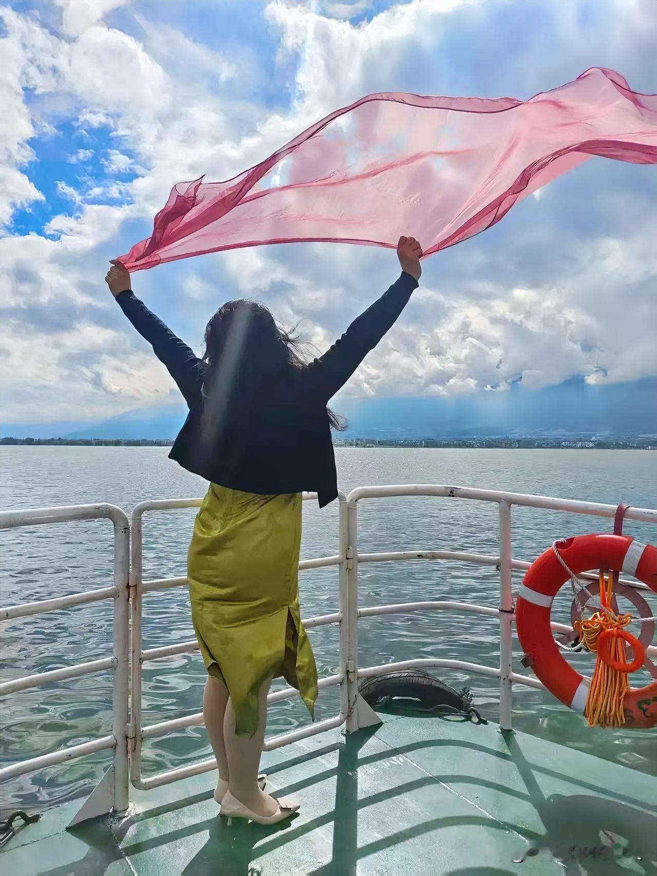 我把脚尖踮在船舷的金属踏板上，纱巾的边角扫过手背，凉丝丝的像碰了把海水。风突然裹