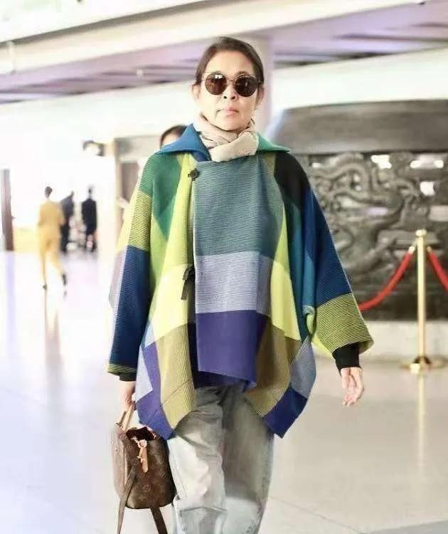 倪萍机场私服太有气场！
彩色格纹斗篷外套搭配牛仔裤，随性又大气。
没有刻意追求显