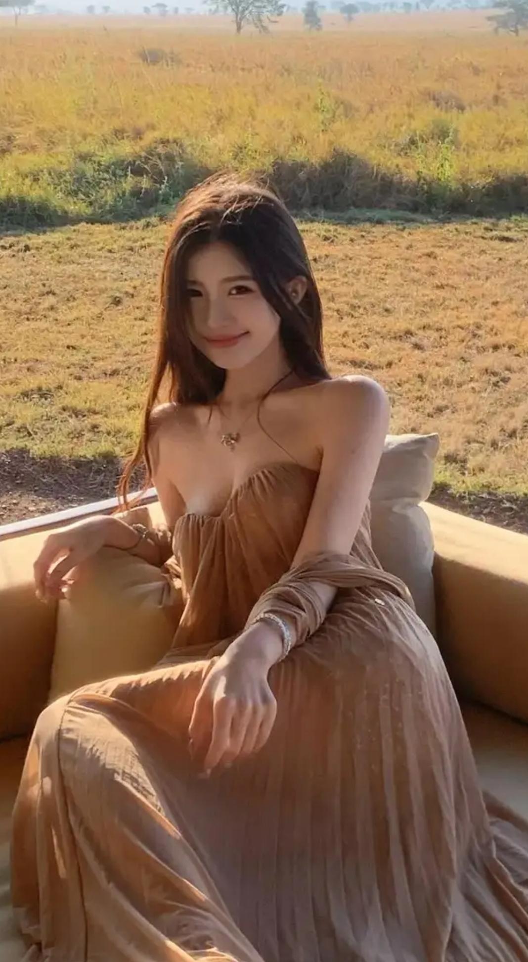 阳光下的优雅时光，浅棕色连衣裙与自然景色完美融合。在这柔和的阳光下，妹子轻轻转动