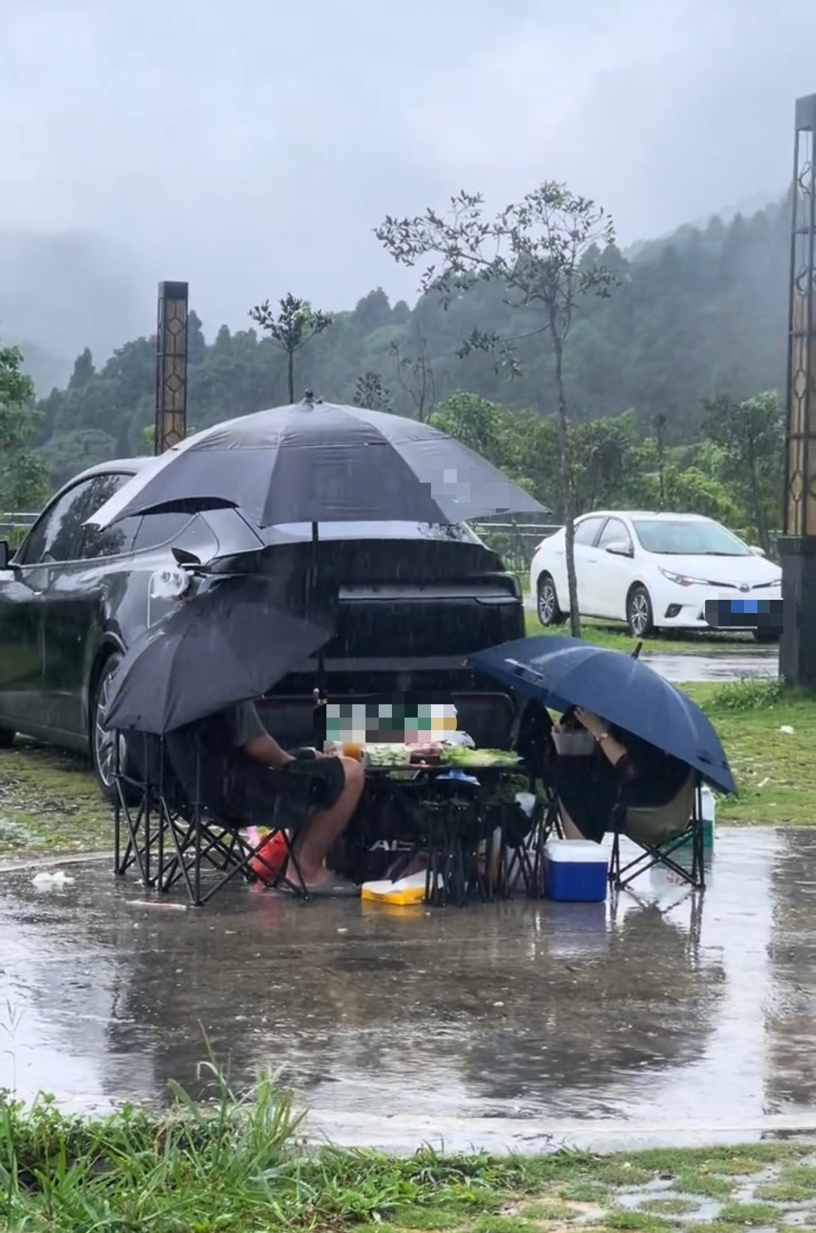 【玉林某景区一对男女在雨中打着伞野餐】6月7日，网友爆料称：玉林下雨天某景区露天