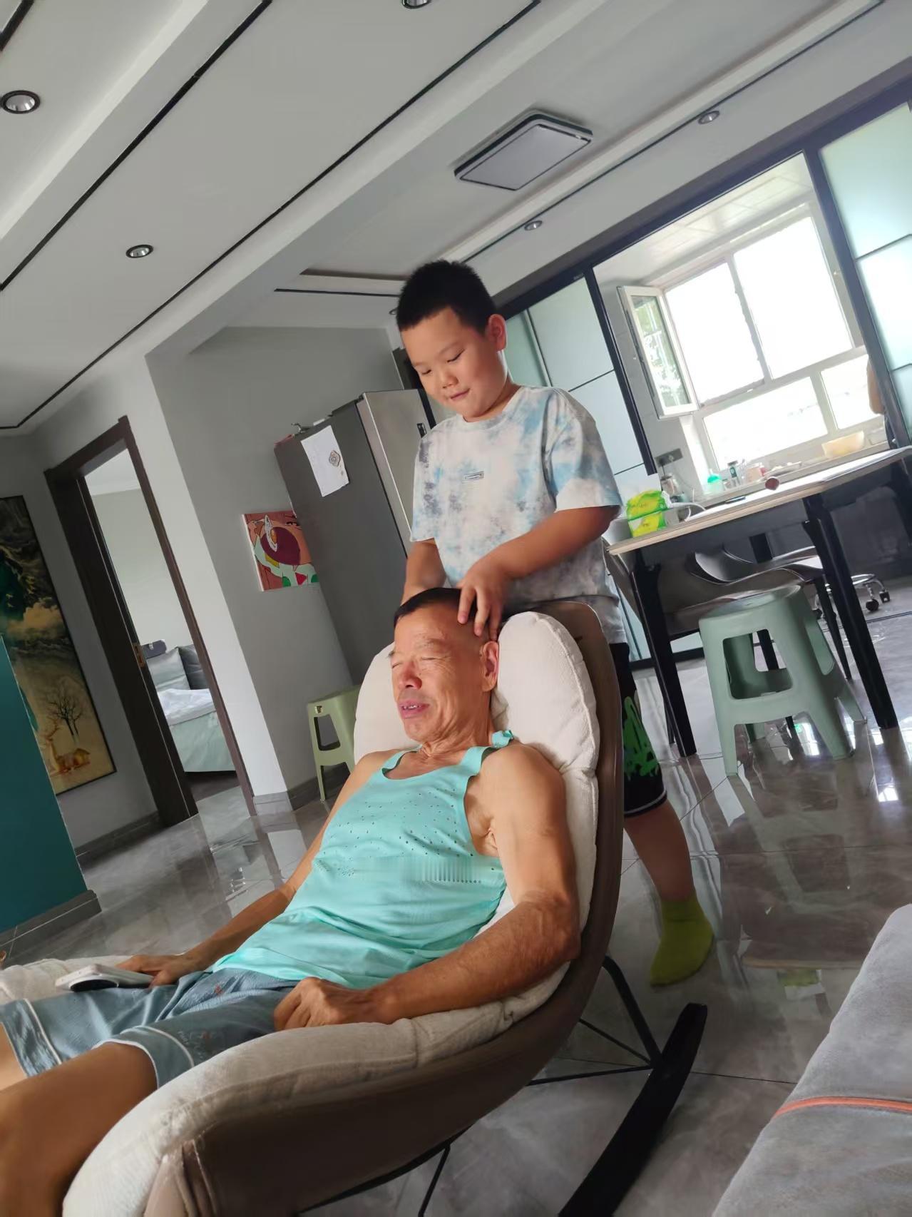 午饭后的这一幕，着实温馨极了！年仅六岁的小娃娃，竟已懂得给爷爷做头部按摩，这般亲