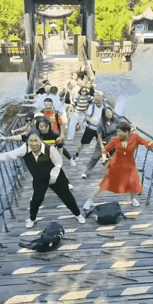 一群大爷大妈旅游，到了空中桥梁直接疯魔了！带头大妈一声喊，两拨人分守左右防护网，