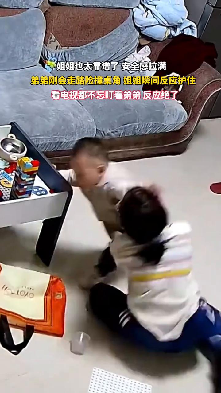 姐姐也太靠谱了，安全感拉满。弟弟刚会走路险撞桌角，姐姐瞬间反应护住，看电视都不忘