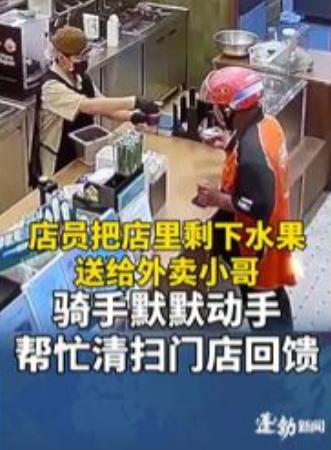 店员把不能过夜的水果递给外卖小哥，小哥伸手接了过来，却没有立刻离开，站在店里四处