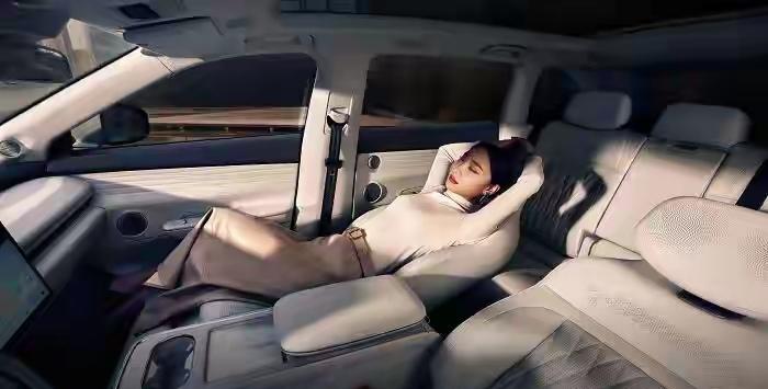 中午12点半，写字楼地库里，一排电车安安静静地亮着空调灯。车里有人躺着刷手机，有