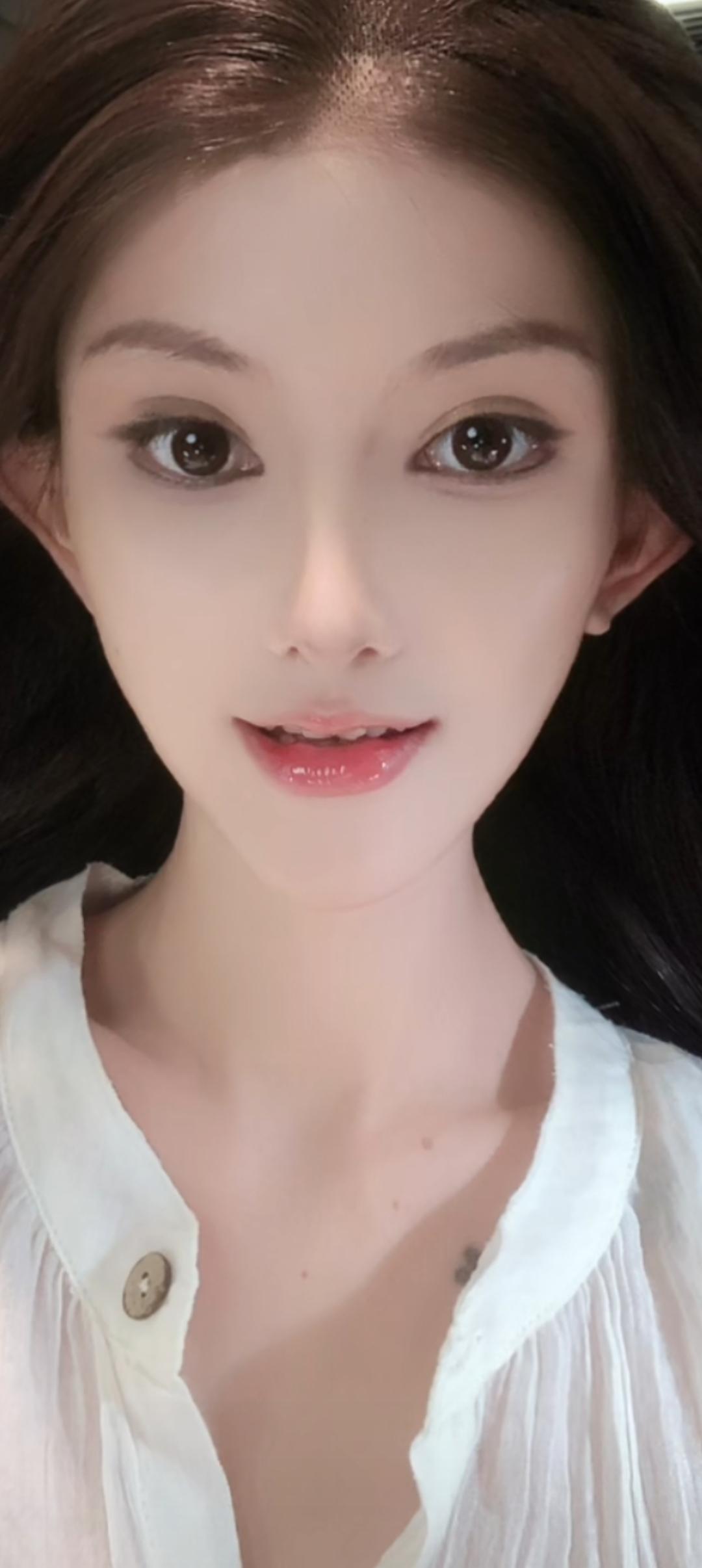 这位小姐姐穿着白色衬衫，皮肤白皙。