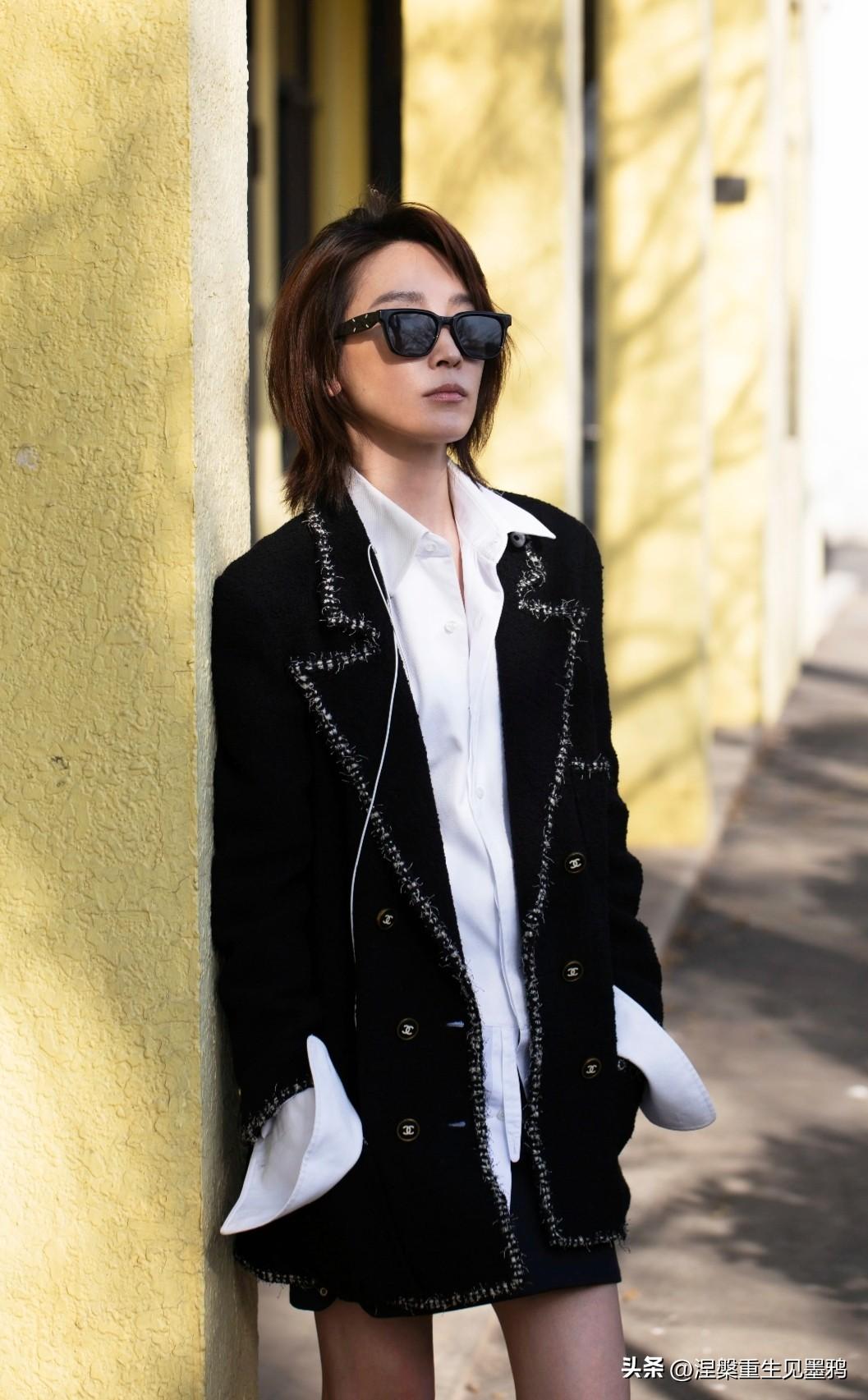 吴京老婆谢楠更新动态，照片中的谢楠倚墙而立，利落短发衬出清瘦轮廓，黑框墨镜掩去眼