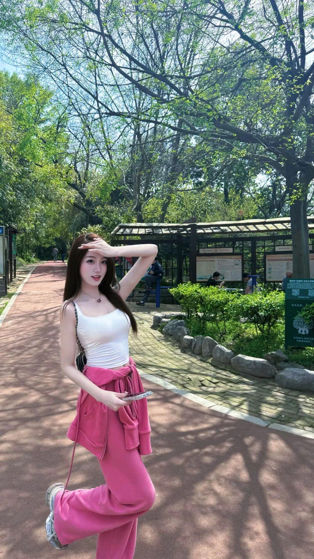 这组照片里的小姐姐，是春日里一抹亮眼的活力粉！
她身着一套玫粉色的休闲运动套装，