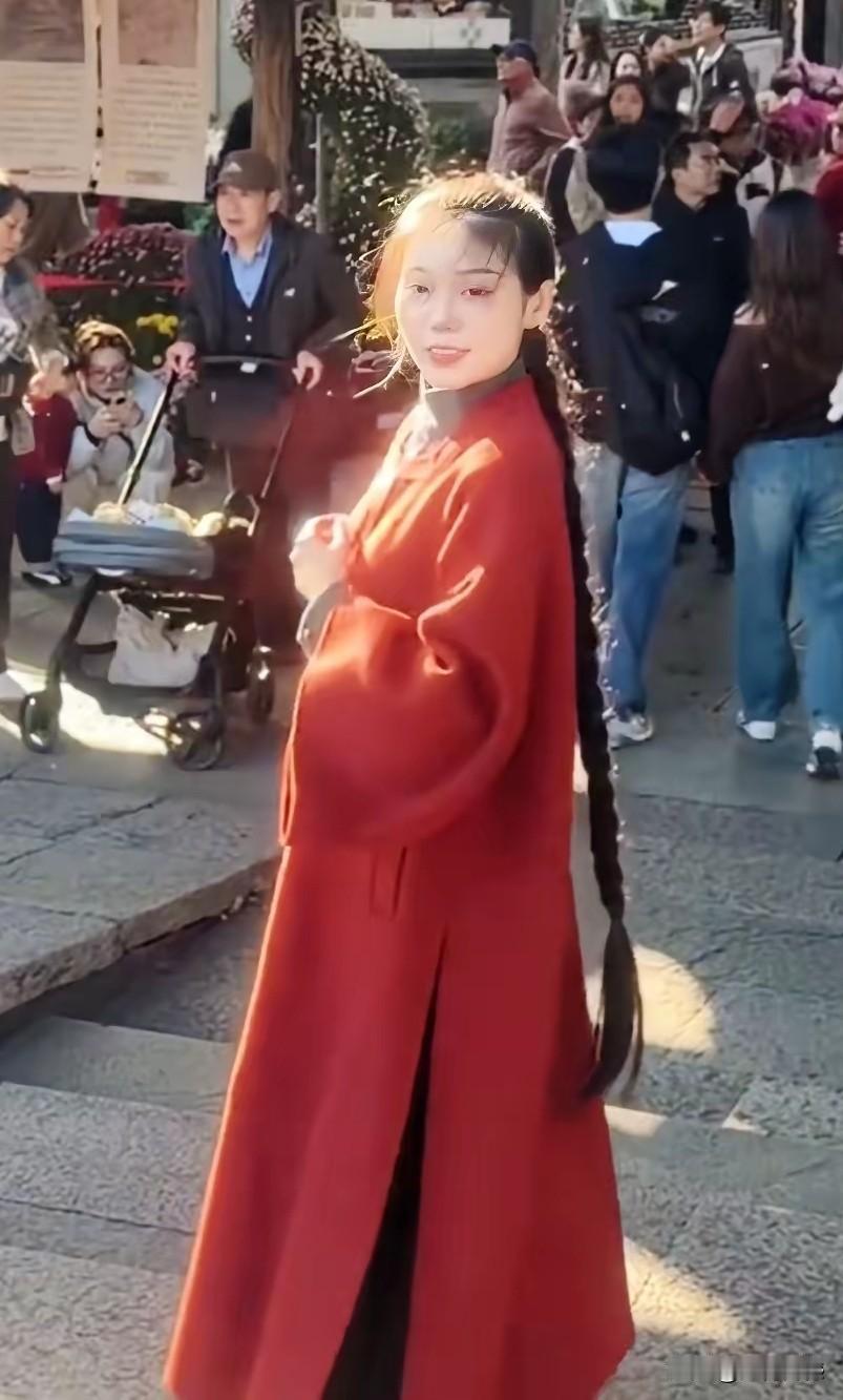 女子的这条大辫子，配上这件红色的衣服，看起来特别的醒目，特别容易吸引别人的目光，