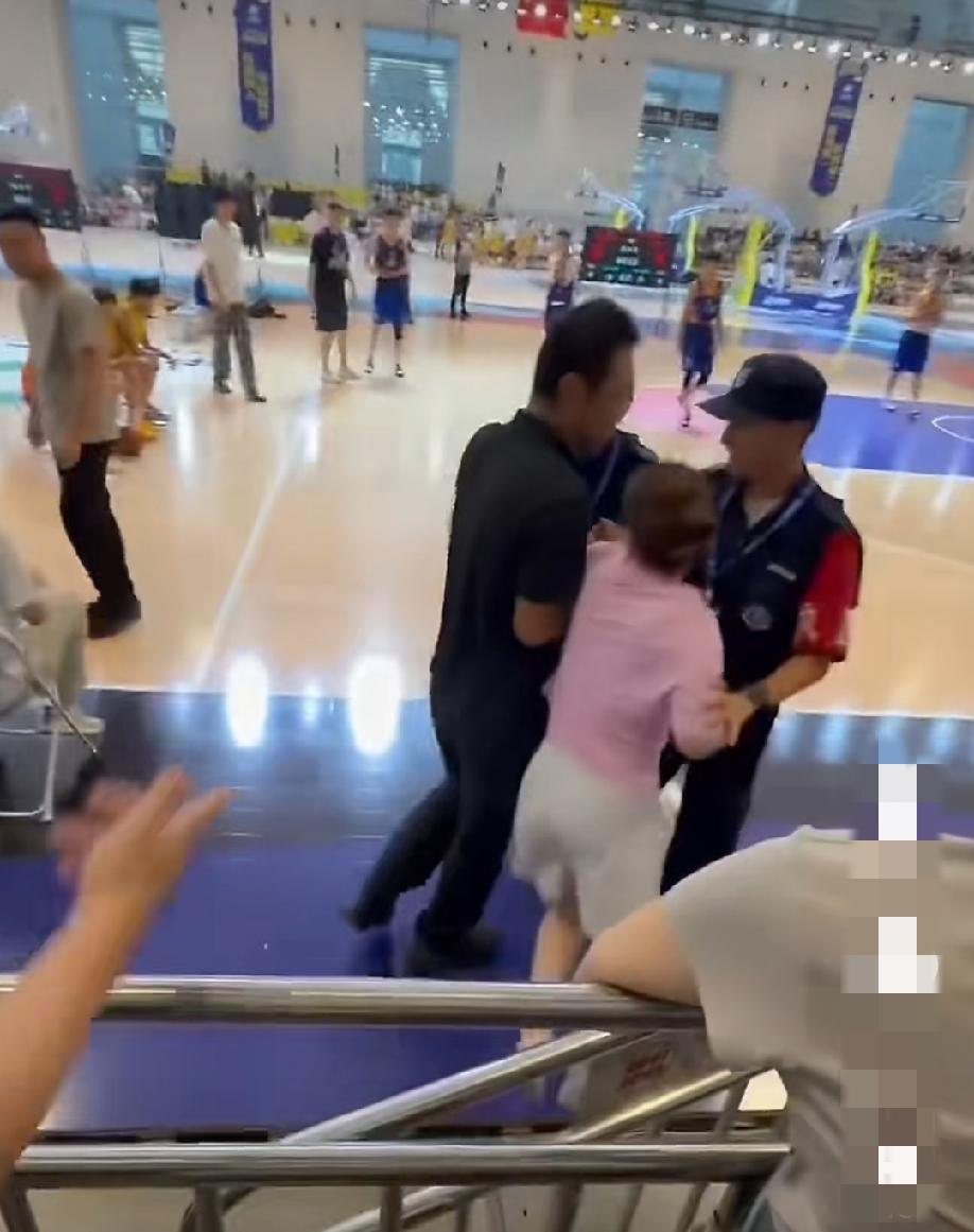 一青少年篮球公开赛上，家长因为儿子争球时摔倒受伤，然后她就在旁边骂裁判。还爬进去