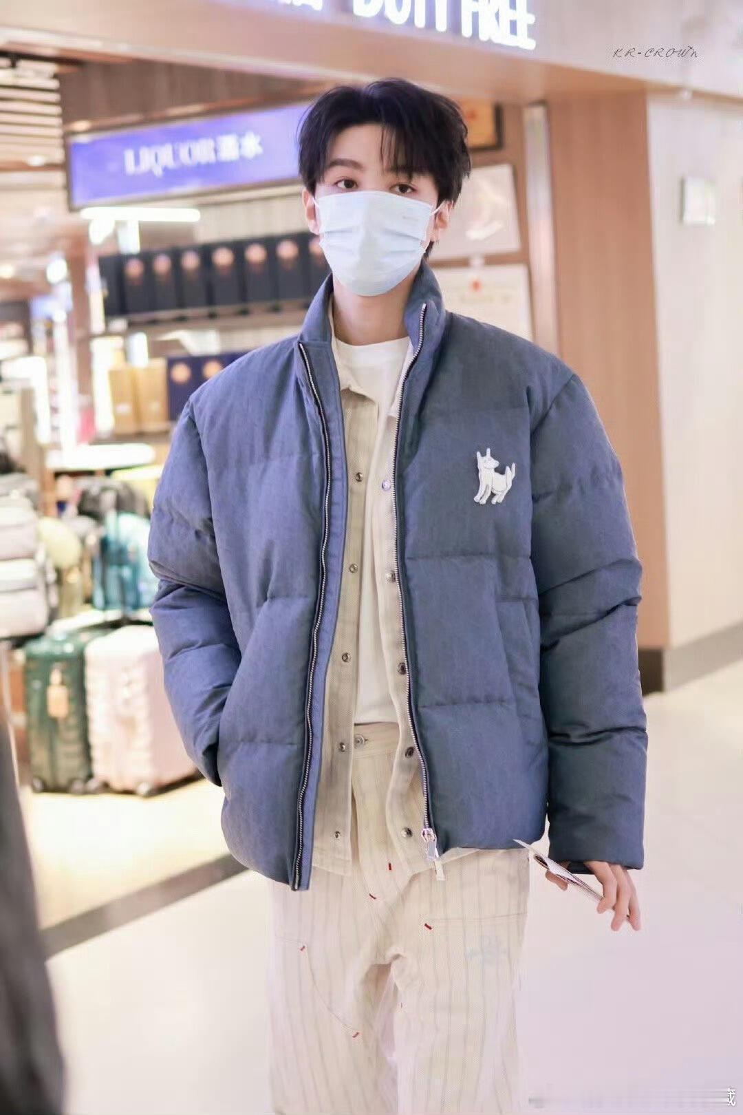 迪奥品牌大使王俊凯，身着蓝色羽绒服并佩戴小狗胸针现身机场，启程前往巴黎。他将受邀