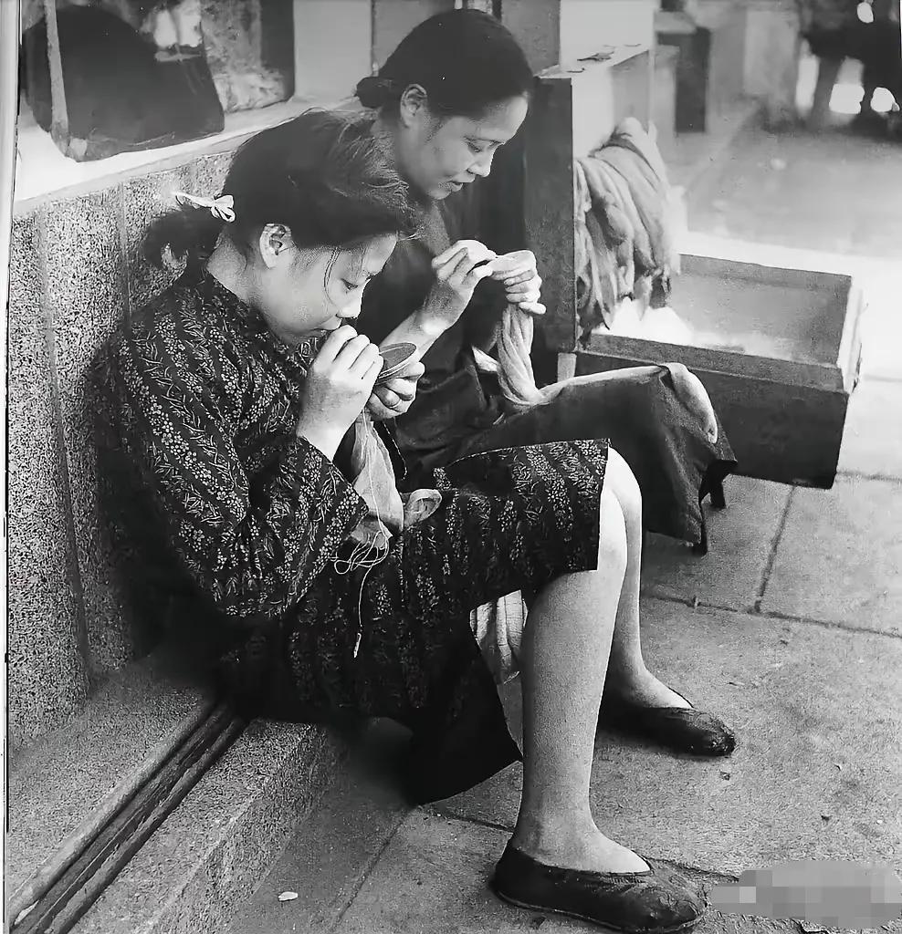 老照片欣赏系列：旧上海街头，专门给人织补衣服的两名女人，织补高级毛料，丝袜，等漏
