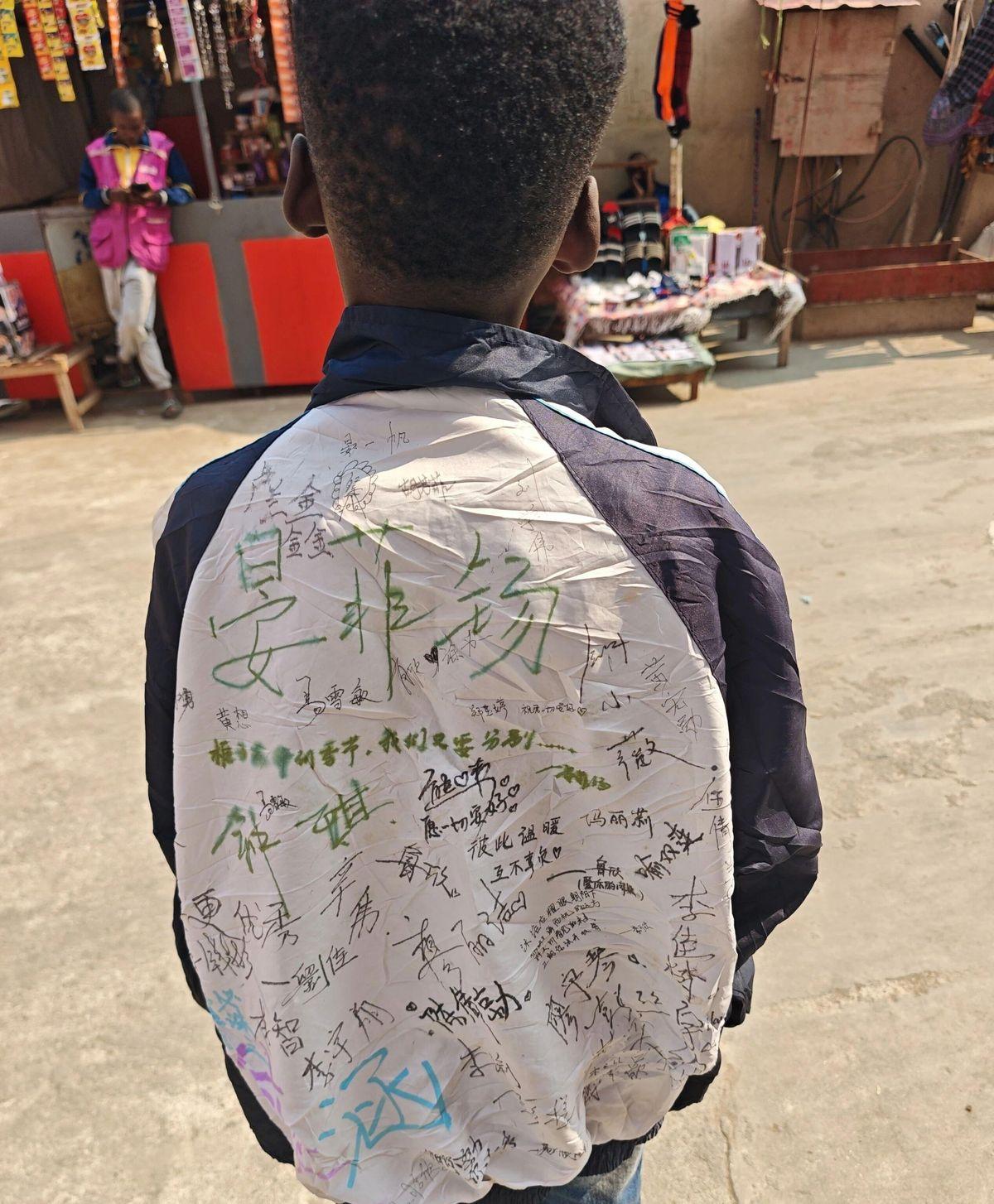 在非洲安哥拉街头，我撞见一个当地小孩，身上穿着件蓝白校服，胸口印着“青岛徐水路小