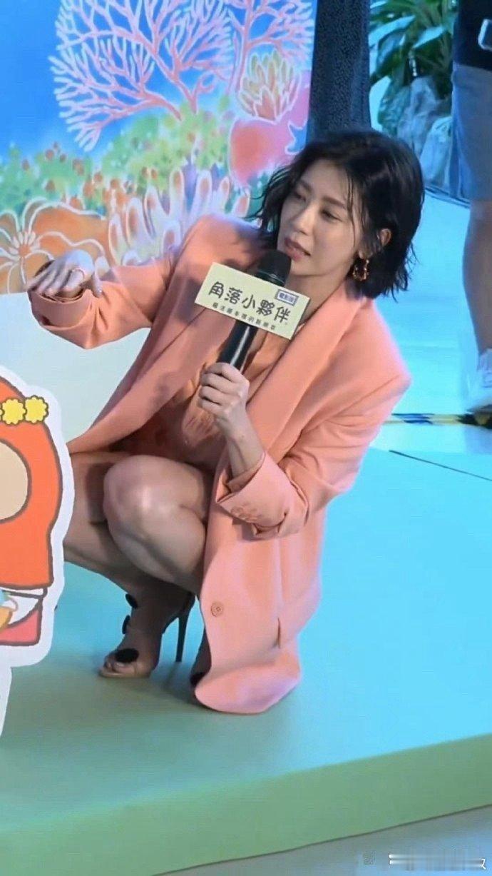 贾静雯50岁，状态依旧出色。她身穿橘色西装搭配高跟鞋，宛如三十岁的白领女性，展现