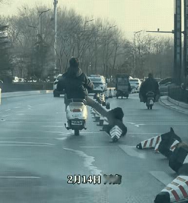 男子一路嬉皮笑脸，骑车踢倒路边的锥桶，还觉得自己特别潇洒，不过是个小恶作剧，根本