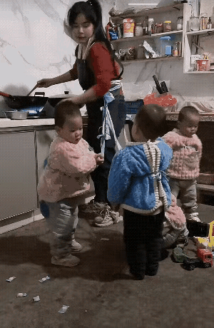 儿多母苦。
这位年轻的妈妈一肚子生下了四个崽，带孩子成了一大重任，弄饭时只得一个