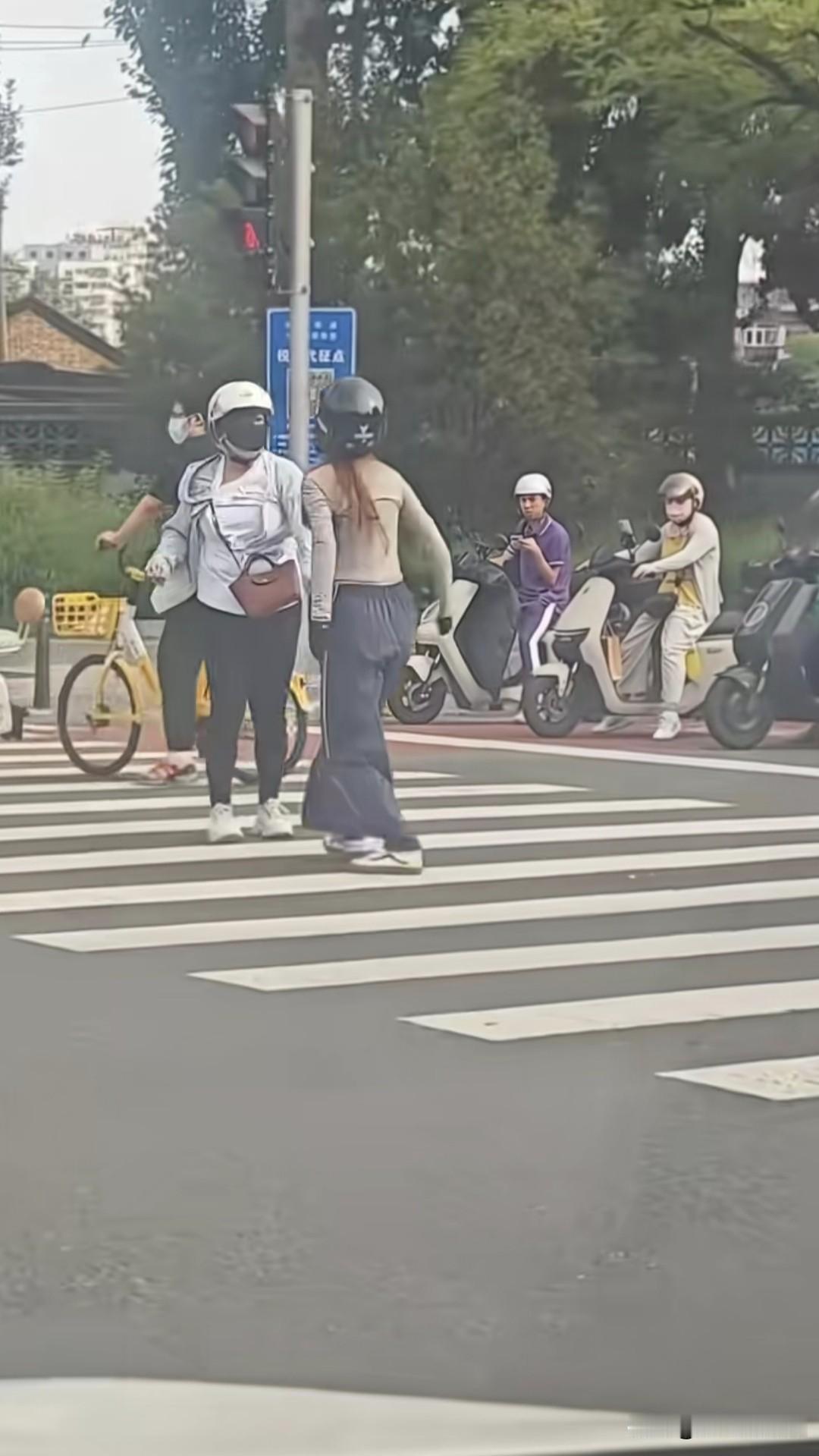 两个骑电动车的女的，就因为前车一个急刹，把后面的女的吓到了，于是就有了在斑马线等