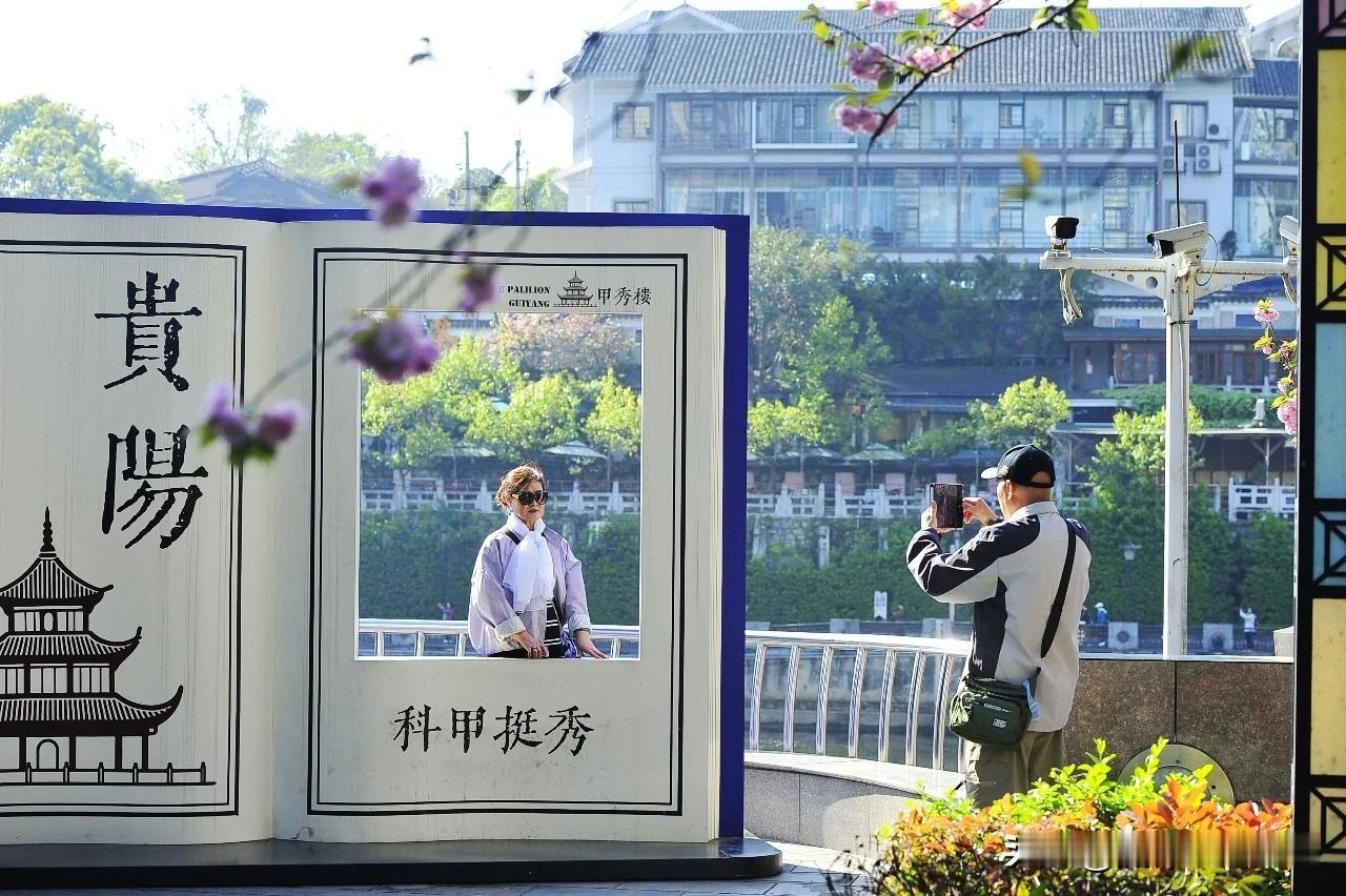贵阳：外地游客在甲秀楼景区打卡

春暖花开，南明河畔河水潺潺流动，柳絮在微风吹拂