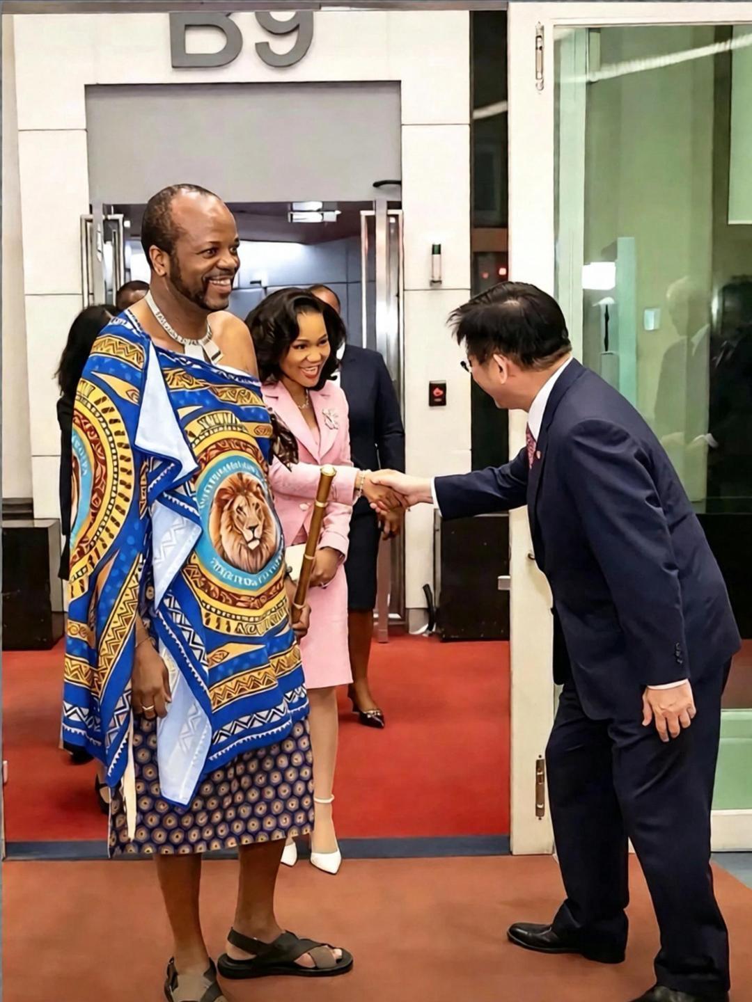 这是斯威士兰国王穆斯瓦蒂三世携妻子窜访台湾时受到台官员迎接的情景。画面中台官员点