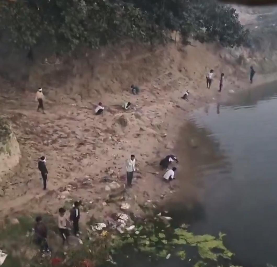 在印度一条河岸的一边，男人们随地大小便，而女人们则在河对岸沐浴的画面。尽管印度的