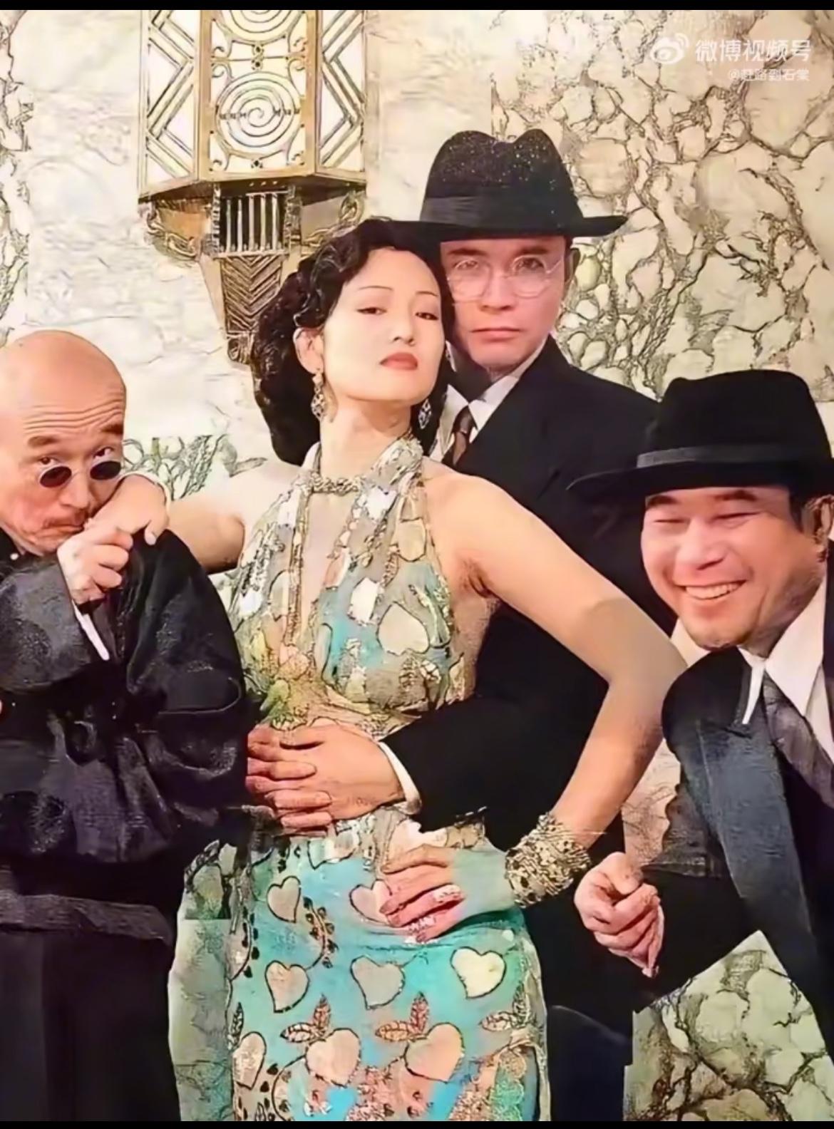这张彩照定格在1995年，是张艺谋《摇啊摇，摇到外婆桥》主创的经典留影。

居中