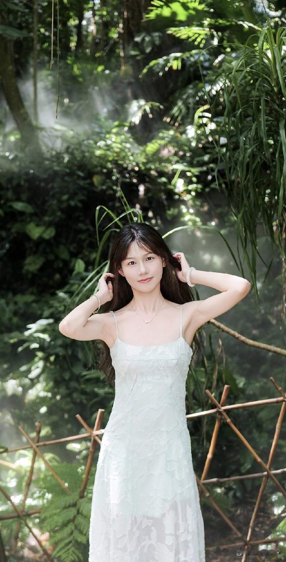 夏日森林中的清新少女，白色连衣裙与绿意盎然的背景相映成趣。