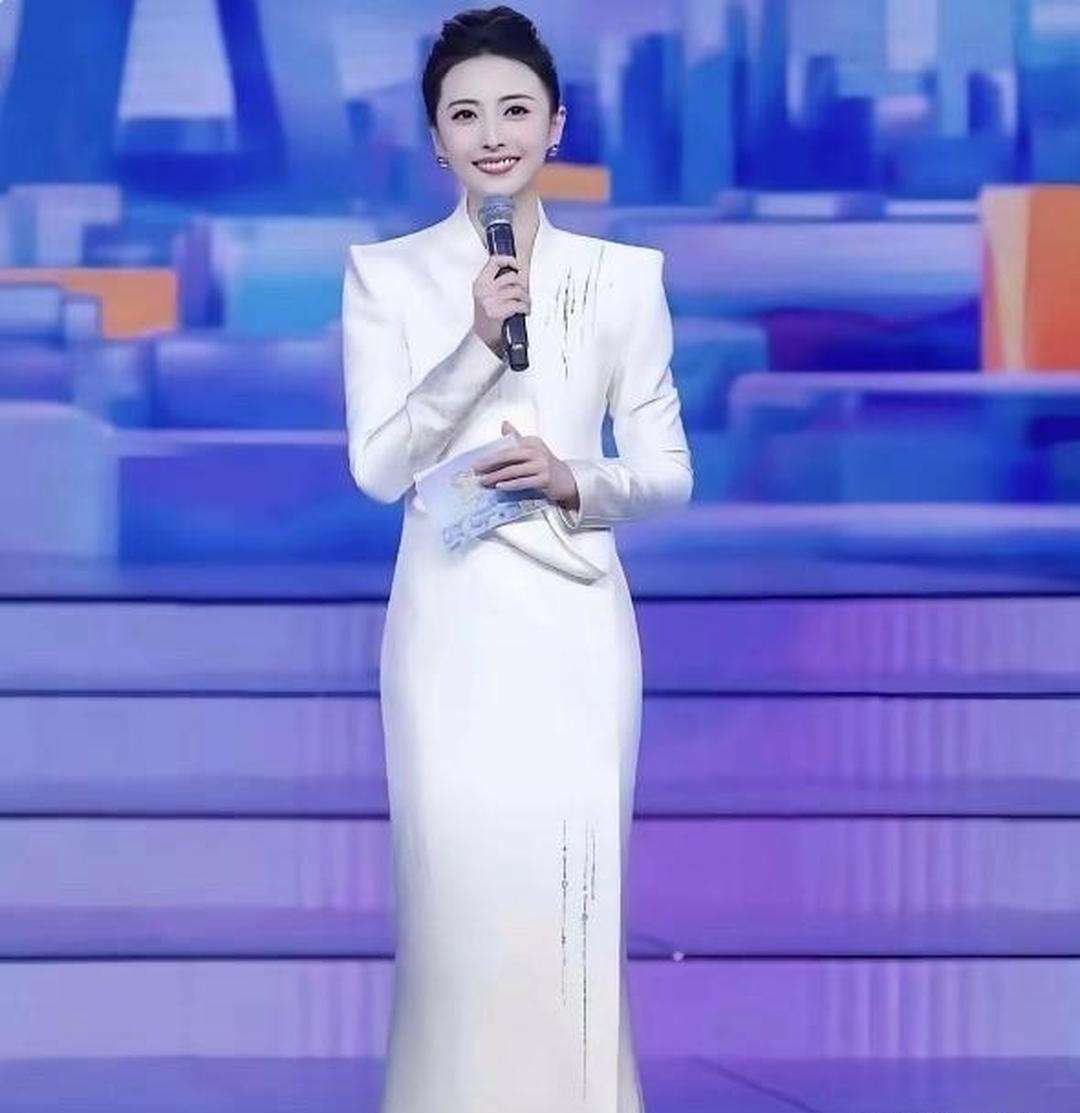 央视出现了一位比龙洋和董卿还显大气的女主持人。她身着一袭米白色长款鱼尾裙，美得动