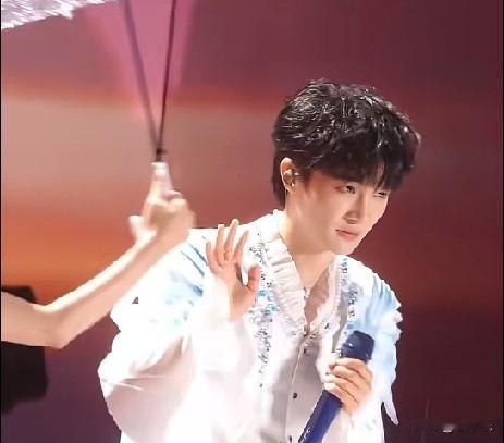 7月18日，上海虹口足球场，《大鱼海棠》十周年演唱会时突降大雨，工作人员为周深递