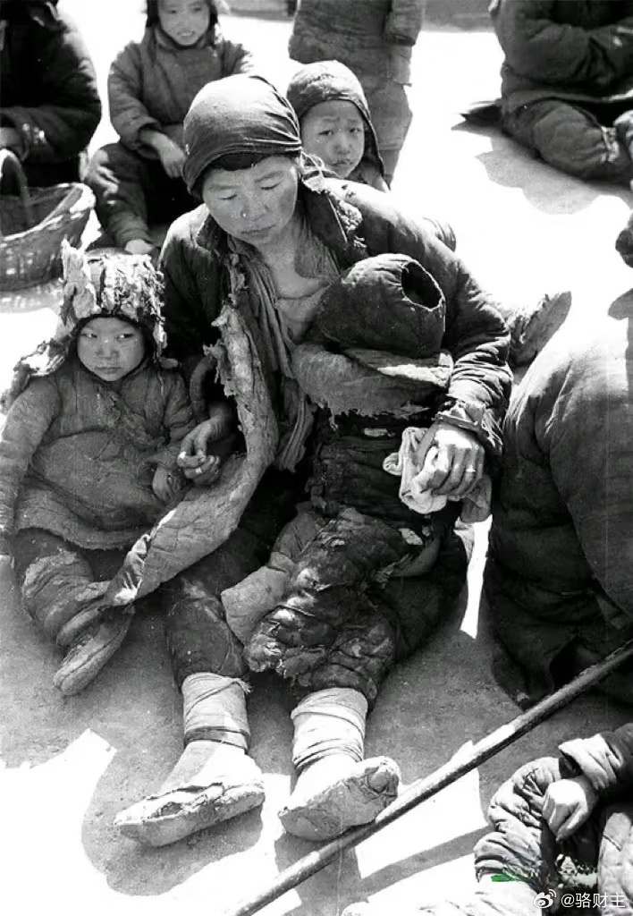 1942年，河南，一位逃荒的母亲和自己两个年幼孩子的合影，她们一家三口坐在地上休