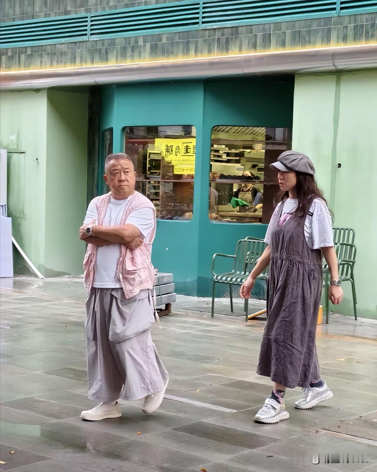 曾志伟和他女友的穿搭好“炸街”，
特别是他宽大的像裙子的裤脚和四个超大的口袋有种