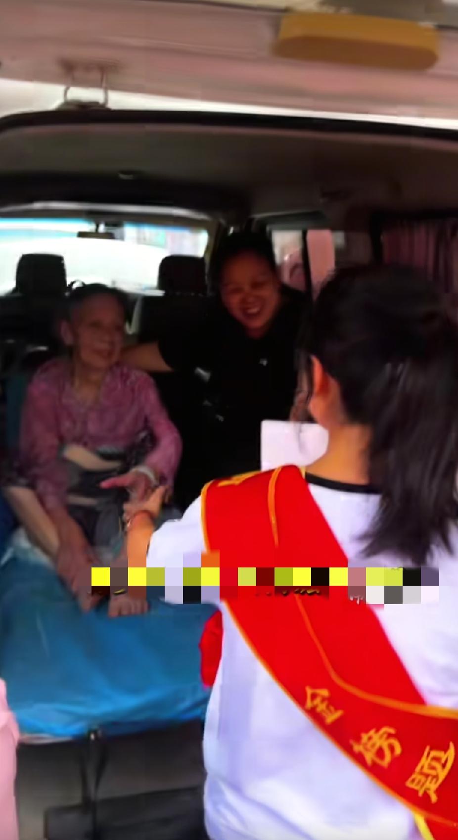 一辆救护车停在了巡游的现场，人群中身披大红彩带的女孩，看见坐在车上的白发老人时，