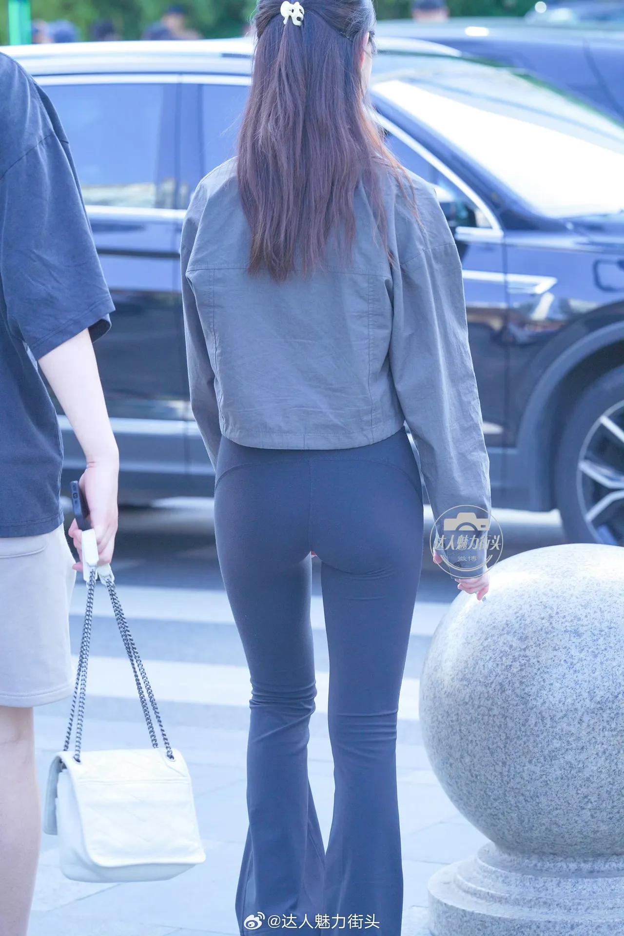 一个长发女生背对镜头走路。