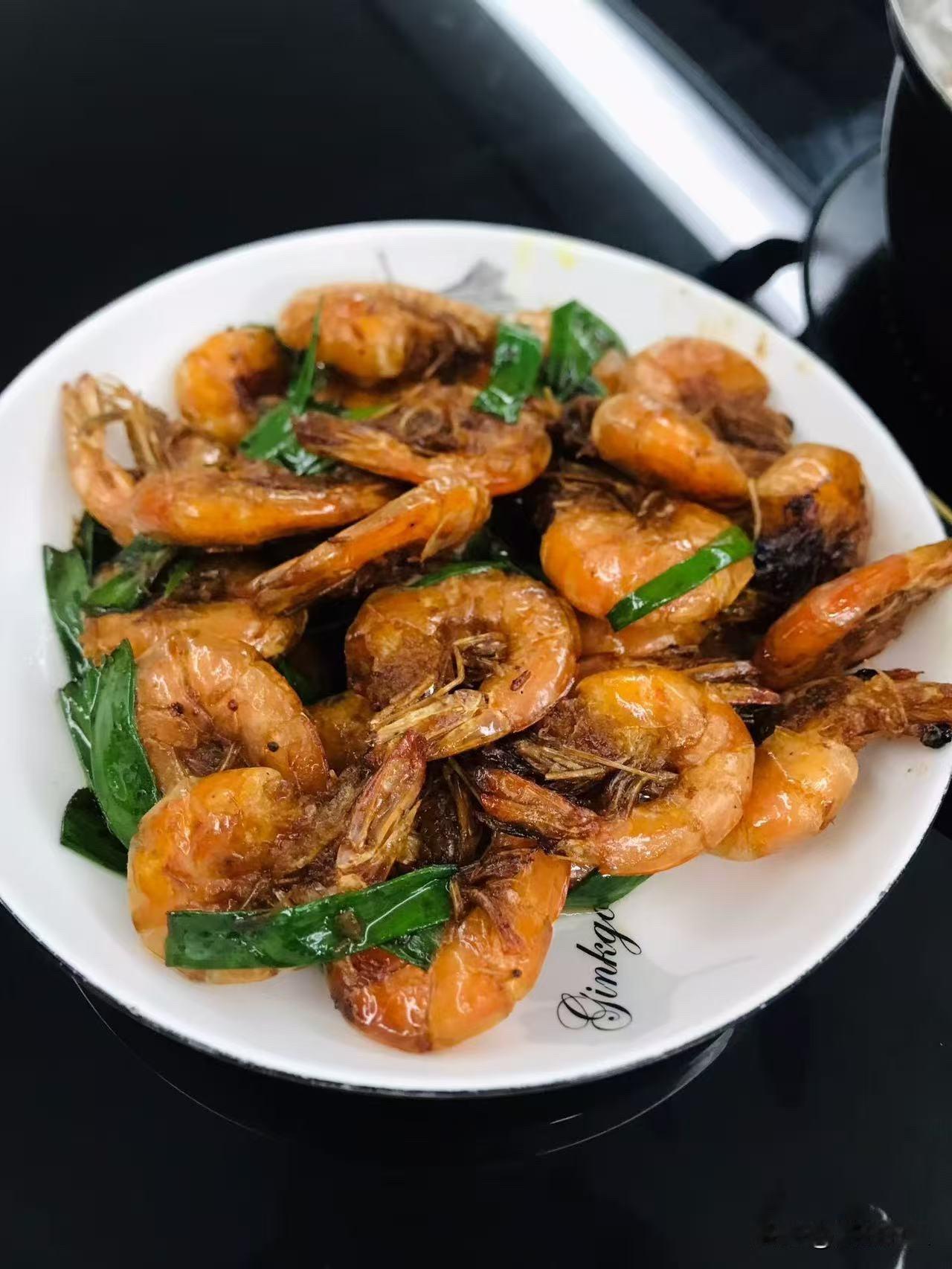 今晚这盘葱香炒虾，下班回家翻出冻虾，简单处理下丢锅里煎到壳儿焦脆，淋点生抽撒把葱