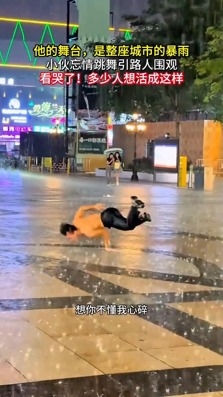 他的舞台是整座城市的暴雨，小伙忘情跳舞引路人围观，看哭了！多少人想活成这样。
可