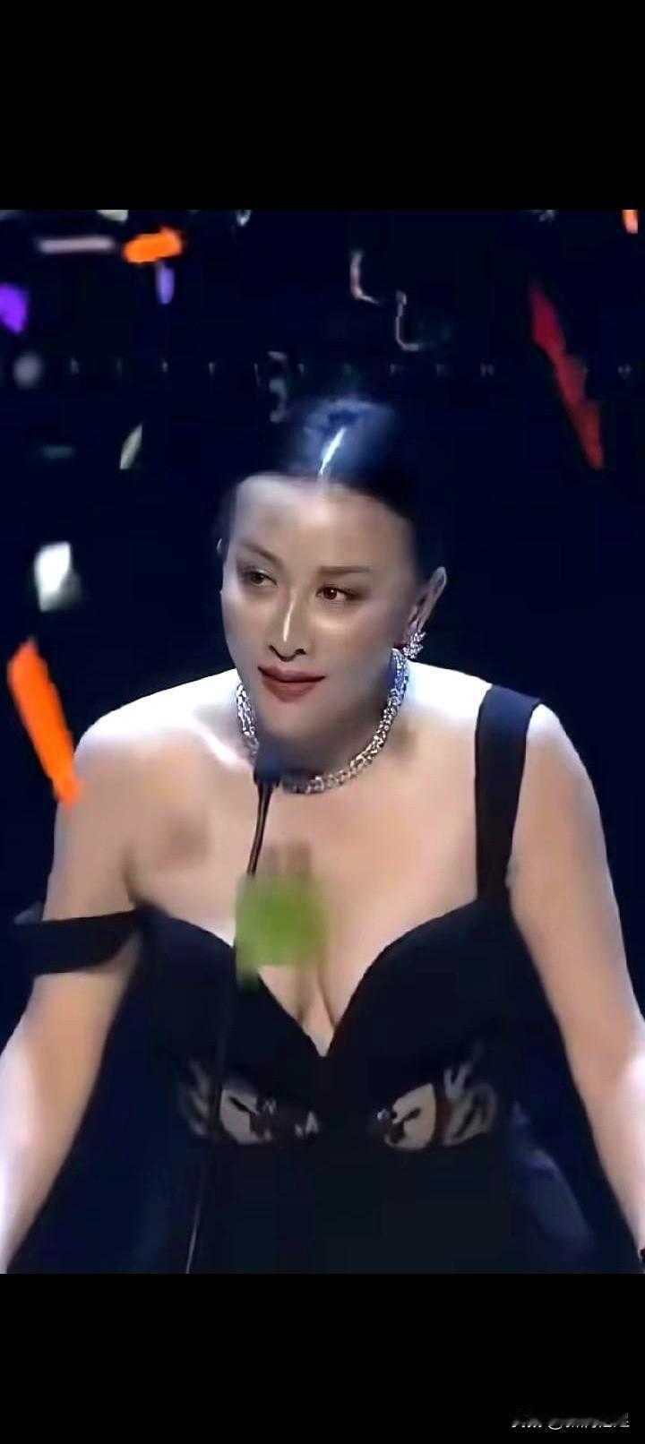 台下闪光灯炙烤着时，香港的演讲台上，刘嘉玲穿着黑色吊带礼服，吊带忽然滑落，那一瞬