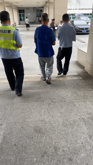网友在医院大门外拍到一个年纪很大的犯人在两名警察的监护下来医院检查身体。
看他身