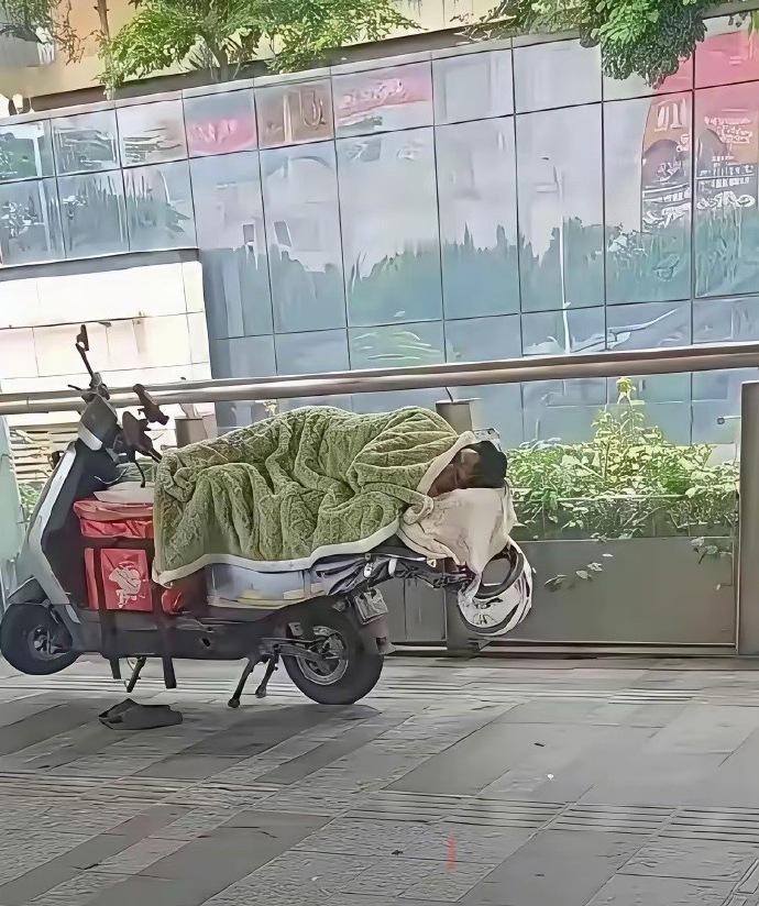 据说这是深圳外卖行业的跑单王，连睡觉都在电动车上，这等神技非常人所能及。 ​​​