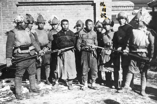 30年代，两名东北抗日联军战士被日军俘虏时的场景，为了炫耀“功绩”，日军摆拍了这...