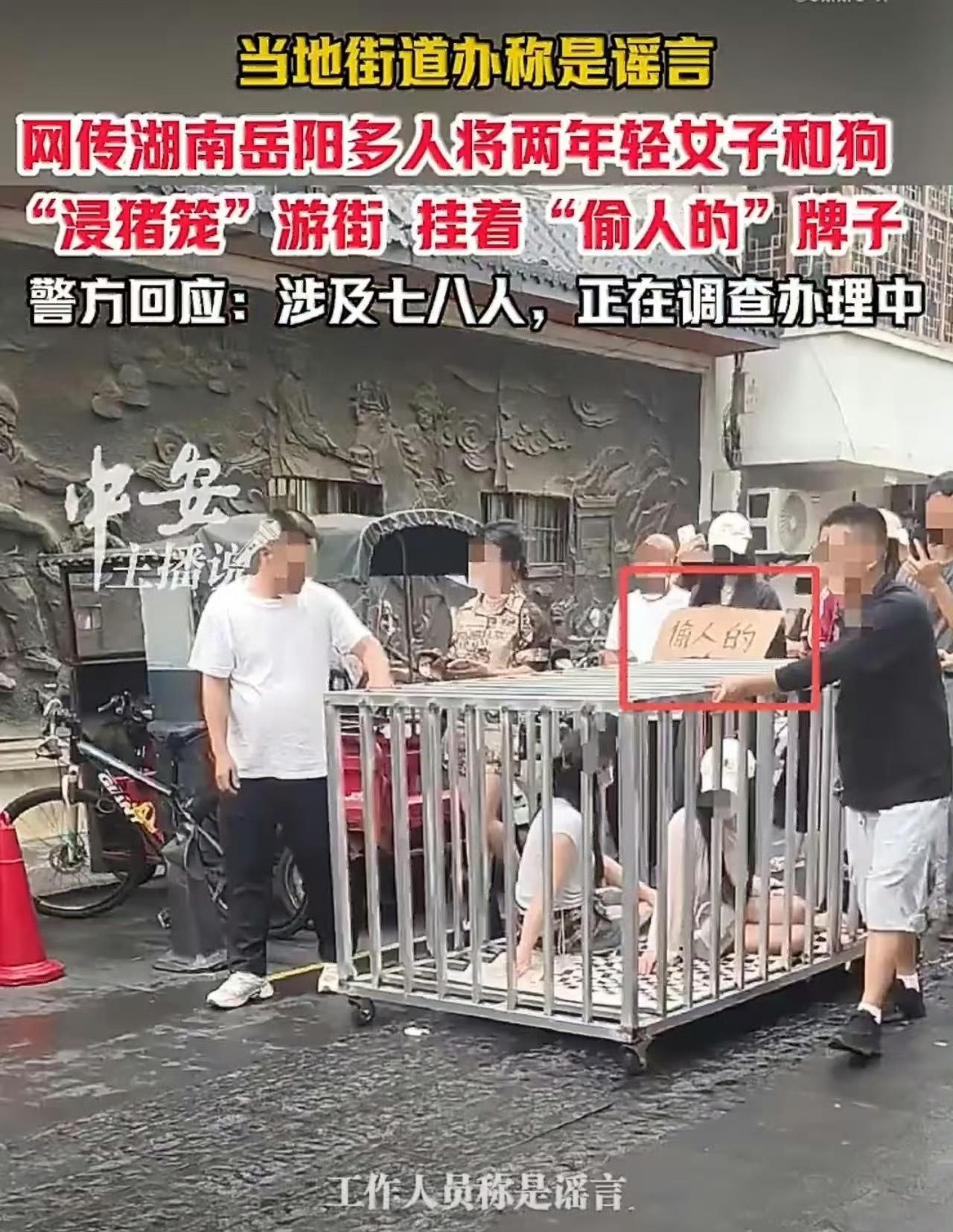 湖南街头，两女子戴口罩被关在笼子里，旁边还有一条狗，不哭不闹不求救，就这么被人推