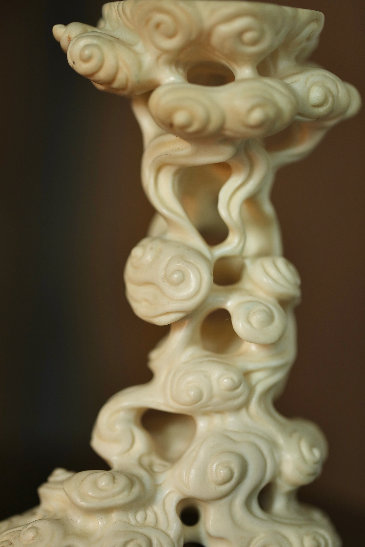 鹿角 | 云纹底座将整料雕作祥云缭绕之态：云纹婉转灵动，卷舒自如，层层叠叠，镂空