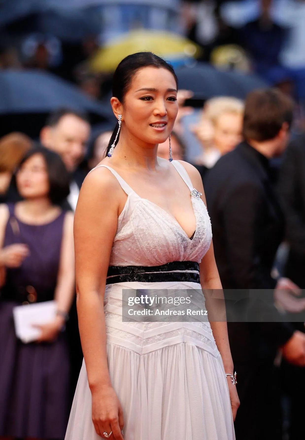 巩俐这58岁状态真的杀疯了！一袭深V白裙配黑腰带，胸腰比惊艳又利落，盘发+红唇气