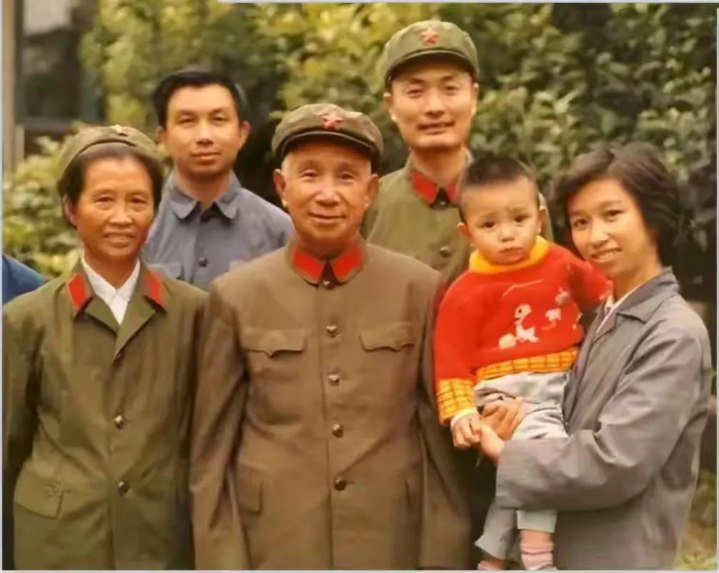 大家仔细看，粟裕大将身后穿军装的男子大家知道是谁吗？
这是一张粟裕大将的全家福，